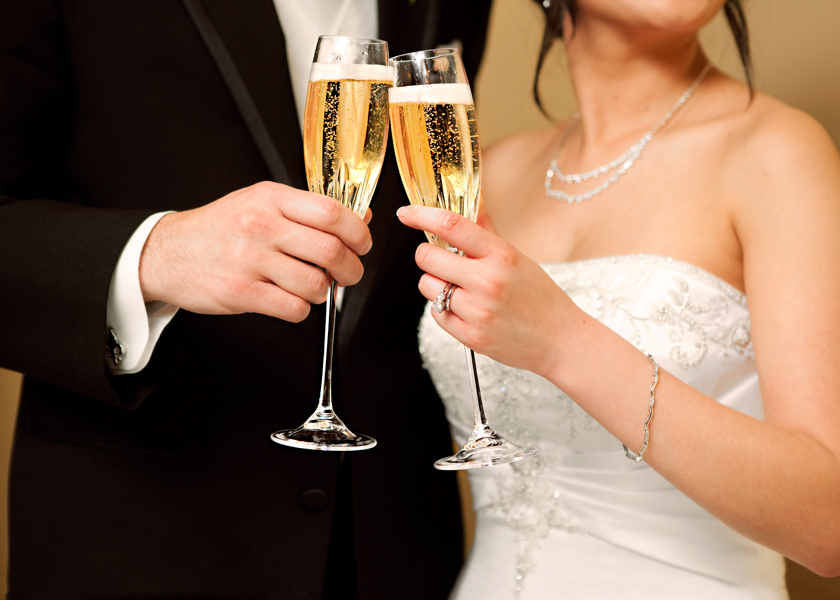 Bride and groom celebrating with champagne at their wedding reception in Devon