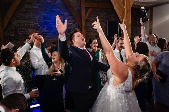 Bride and groom celebrating on the dance floor with guests enjoying a wedding reception by Sherwood Entertainments